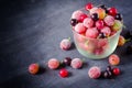 Frozen and fresh berries in a glass pial on a black background. Royalty Free Stock Photo