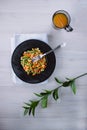 Frozen fried vegetables on black plate. Vegan breakfast with juice. Vegetables food mix on white wooden background with plant Royalty Free Stock Photo