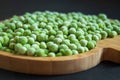 frozen frosty green peas on wooden plate closeup Royalty Free Stock Photo