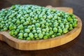 frozen frosty green peas on wooden plate closeup Royalty Free Stock Photo