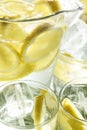 Frozen Glass Pitcher With Lemonade With Ice And Pieces Of Lemon Surrounded By Glasses Of Water With Lemon. Refreshing Summer Drink