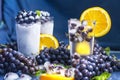 Frozen grapes in glass of water with orange and ice close-up Royalty Free Stock Photo