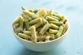 Frozen green beans vegetables in white bowl on blue background Royalty Free Stock Photo