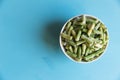 Frozen green beans vegetables in white bowl on blue background Royalty Free Stock Photo
