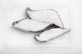 Frozen Greenland halibut steaks vacuum pack, on white stone table background, top view flat lay Royalty Free Stock Photo