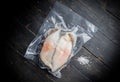 Frozen Greenland halibut steaks vacuum-packed on the wood cutting board