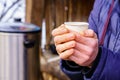Frozen hands hold a disposable paper cup with hot tea. Warming in cold winter. Selective focus. Background Royalty Free Stock Photo