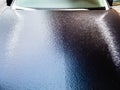 Frozen hood of dark blue car after freezing rain