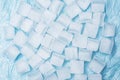 Frozen ice cubes for drinks arranged in a scattered pattern on a blue surface Royalty Free Stock Photo