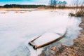 Frozen Into Ice Of River, Lake Old Wooden Boat. Abandoned Rowing