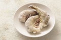Frozen king prawns without head on a plate, light background Royalty Free Stock Photo