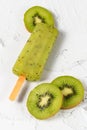 Frozen kiwi fruit ice or sorbet or popsicle with slices on white cement Royalty Free Stock Photo