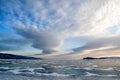 Frozen Lake Baikal. Beautiful stratus clouds over the ice surface on a frosty day. Royalty Free Stock Photo