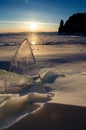 The frozen Lake Baikal. Winter landscape with ice and snow near the rocks of Olkhon Island in the sunset Royalty Free Stock Photo