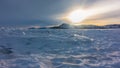 The frozen lake is covered with snow. Turquoise hummocks are visible in the distance Royalty Free Stock Photo