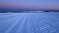 Frozen Lake Covered with Snow on a Winter Evening, with Snowmobile Tracks Royalty Free Stock Photo