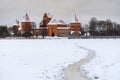 Frozen lake Galve and path to the historical Trakai stone castle in winter, front view, Lithuania.