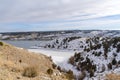 Frozen lake and hills blanketed with snow under cloudy blue sky in winter Royalty Free Stock Photo