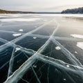 Frozen lake landscape featuring a smooth ice surface with intersecting cracks and Royalty Free Stock Photo