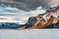 Frozen Lake Minnewanka with rocky mountains in winter at evening Royalty Free Stock Photo