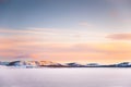 Frozen lake with mountains at sunset