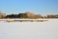 A frozen lake and pier on a frosty, sunny winter day