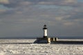 Frozen Lake Superior shoreline with lighthouse and shipping pier Royalty Free Stock Photo