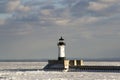 Frozen Lake Superior shoreline with lighthouse and shipping pier Royalty Free Stock Photo