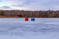 Ice fishing; Frozen lake surface in winter with two ice shanties on the frozen lake surface. Royalty Free Stock Photo