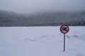 Frozen lake covered in snow in the winter with swimming not allowed sign Royalty Free Stock Photo