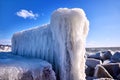 Frozen lighthouse and pier on stormy winter day