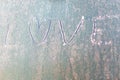 Frozen love on car window with heart shape on frosty windscreen