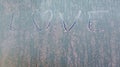 Frozen love on car window with heart shape on frosty windscreen