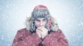 Frozen man in red winter clothes warming hands, cold, snow, frost, blizzard Royalty Free Stock Photo