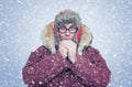 Frozen man in winter clothes warming hands, cold, snow, blizzard Royalty Free Stock Photo