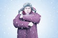 A frozen man in winter clothes waves his hands to keep warm, steam is coming out of his mouth, on a blue background Royalty Free Stock Photo