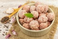 Frozen Meatballs With Spices, Basil Leaves, And Garlic Cloves In A Ceramic Bowl