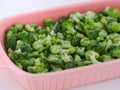 Frozen mini broccoli in a pink baking tray