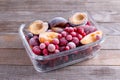 Frozen mixed fruits-berries in a glass container on a wooden table Royalty Free Stock Photo