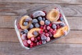 Frozen mixed fruits-berries in a glass container on a wooden table. Selective focus. Top view Royalty Free Stock Photo