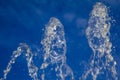 Frozen in motion jet beautiful clean waters flow, bubbling and splashing and spray droplets from a fountain against the blue sky Royalty Free Stock Photo