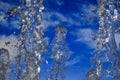 Frozen in motion jet beautiful clean waters flow, bubbling and splashing and spray droplets from a fountain against the blue sky Royalty Free Stock Photo