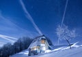 Frozen mountains cabin under a night sky filled with stars