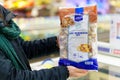 Frozen mushroom mix in the package in the hand of the customer.February 2, 2023 Balti, Moldova. Illustrative editorial