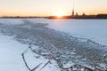 Frozen Neva river in St. Petersburg in winter at sunset with sun rays