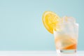 Frozen oranges alcohol drink with orange liquor, sliced fruit, ice cubes in misted shot glass on  blue pastel background. Royalty Free Stock Photo