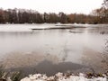 frozen over winter lake surface water trees white sky nature cracks Royalty Free Stock Photo