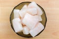 Frozen Pangasius, Dory fish cut in cube in glass bowl, top view.