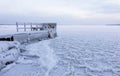 Frozen pier next to wintry lake Royalty Free Stock Photo