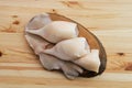 Frozen pilled squid on wooden plate